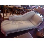 A white painted chaise longue, upholstered in striped fabric, raised on turned supports,
