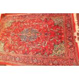 A Persian Kashan rug, the medallion on a red field with ivory spandrels,