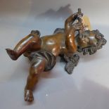 A bronze figure of a cherub playing a fl