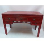A Chinese red lacquered side table with an arrangement of five drawers,