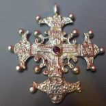 A silver ornate cross pendant,