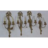 A set of four late 19th Century carved giltwood two branch wall lights.