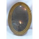 A Regency mirror in oval form with distressed mercury glass having egg and dart border c.