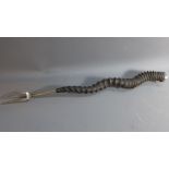A toasting fork, rib turned horn and white metal handle,