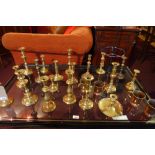 A large collection of brass candlesticks