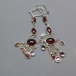 A pair of silver and garnet drop earrings,