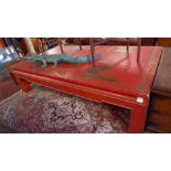A large red lacquered, gilded and painted chinoiserie style centre or coffee table.
