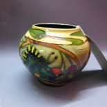 A Moorcroft squat vase decorated with butterflies, caterpillars and flowers dated 2004.