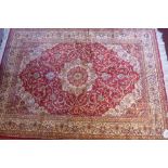 A Keshan style red ground carpet with central floral medallion contained by borders 190cm X 140cm