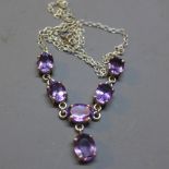 A silver necklace set with faceted amethysts