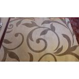 A contemporary woolen rug with leaf design on a cream ground 232cm X 160cm