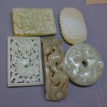 A collection of Chinese carved jade items to include a belt buckle, two pendants,