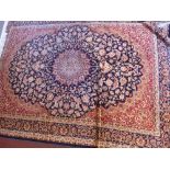 A Keshan style blue ground carpet with central floral medallion contained by borders 230cm X 160cm