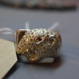 A silver ring with panther head design set with ruby eye