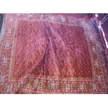 A Bokhara style red ground carpet with elephant pad motifs contained by borders 280cm X 200cm