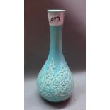 An Islamic turquoise ceramic pear shape vase decorated with calligraphy.