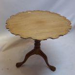 A Chippendale style walnut tilt top table with pie crust top raised on bird cage mechanism,