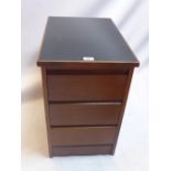 A teak side chest of three drawers with black vinyl top.