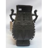 A bronze Chinese Ming style vase with twin phoenix head handles and decorated with stylised symbols