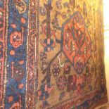 A Shirvan rug, geometric spandrel design over honey ground within indigo stylised flower border,