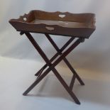 A regency mahogany butler tray with scalloped rim on stand