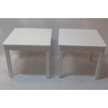 A pair of white modern coffee tables having cut out heart design.