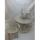 A white painted cast iron circular garden table together with two pairs of cast iron chairs.