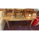 A pine kitchen dining table raised on turned legs,