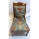 An Art Nouveau oak chair with William Morris style fabric, raised on turned legs and castors.