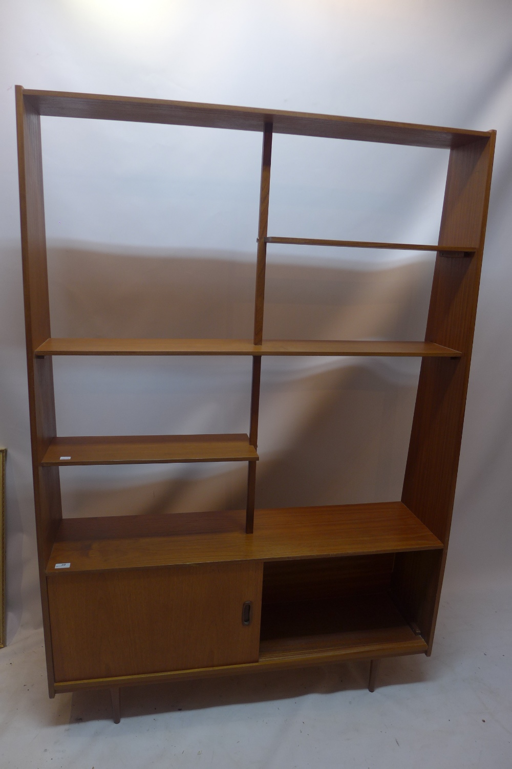 A vintage 20th Century teak display bookcase shelf unit above cupboard with sliding doors H: 168cm