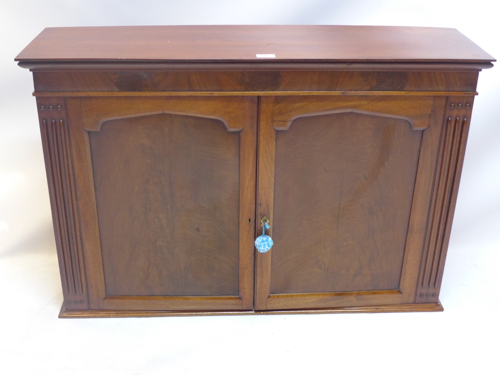 A William IV mahogany wall hanging cabinet with two doors enclosing shelves and two drawers.