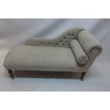 A contemporary chaise lounge with button back stone linen upholstery raised on turned mahogany legs