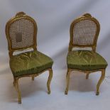 A pair of giltwood hall chairs with cane back and raised on cabriole legs.