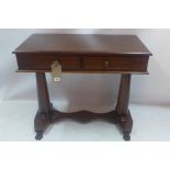 A mahogany side table with two drawers, raised on fluted supports joined by stretcher and paw feet.