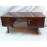 A 1950s mahagony mid century desk having tambour sliding door enclosing bar