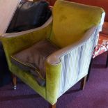 A pair of contemporary arm chairs with grey leather arms and upholstered in a green velour raised