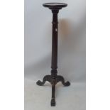 A Georgian style mahogany torchere raised on reeded column, three splayed legs and paw feet,