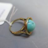 A yellow metal ring set with turquoise stone