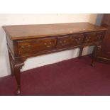 A George 1st oak dresser base with three drawers and raised on cabriole legs.