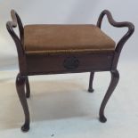 A 19th century mahogany piano stool with hinge lidded compartment and raised on cabriole legs.