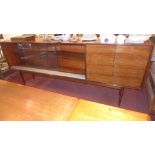 A mid 20th Century rosewood sideboard with two sliding glass doors beside two cupboard doors raised