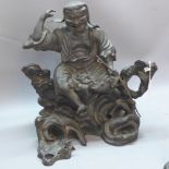 A 19th Century Chinese bronze figural study of a scholar sitting on a rocky out crop,
