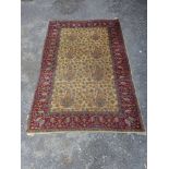 A Kirman carpet, possibly Qom, leaf design over honey ground within red foliate border,