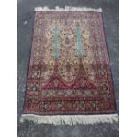 Qom silk rug, mirab design over cream floral ground, indigo border,