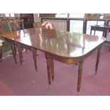 A regency style mahogany dining table raised on fourteen turned gun barrel legs and castors.
