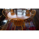 A 20th Century Ercol elm dining table and four stick back chairs 104cm x 120cm