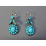 A pair of yellow metal earrings set with turquoise stones.