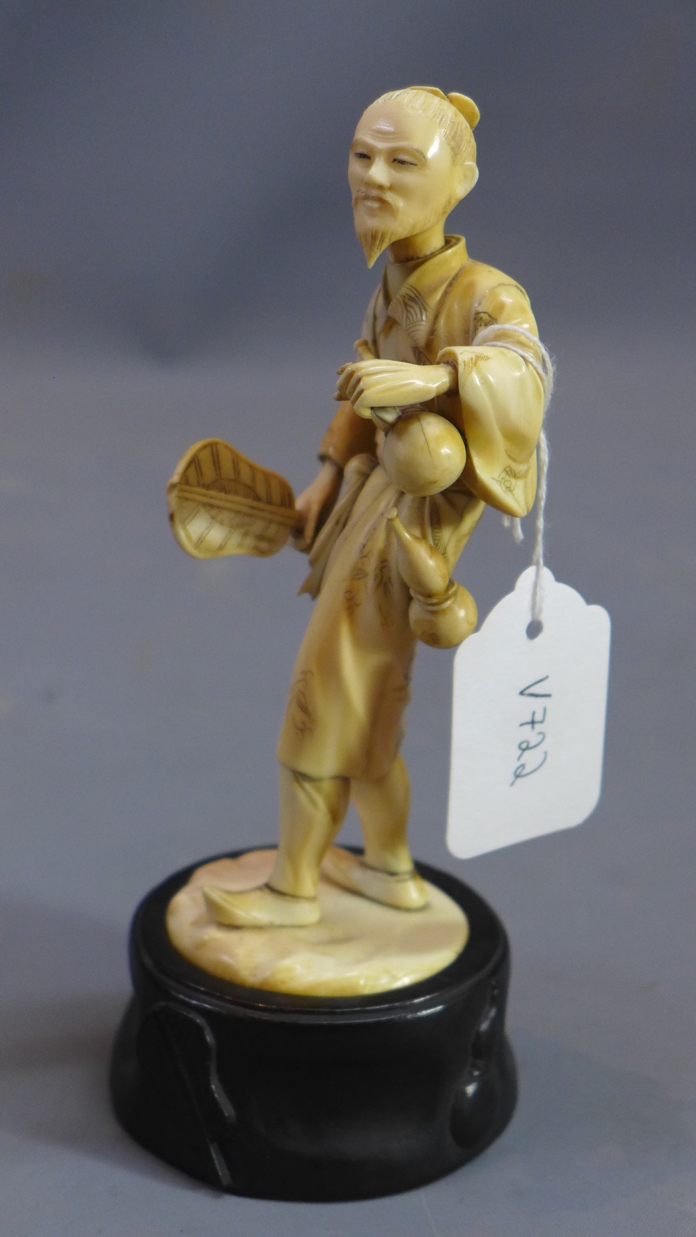 A 19th Century Japanese ivory carving of a man carrying two gourds and a fan. - Image 2 of 6