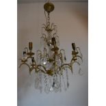 A early 20th century chandelier fitted for electricity with glass droppers hanging from gilded