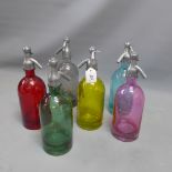 A set of six multi coloured soda syphones.